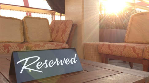cabana chairs and table with a sign that says reserved
